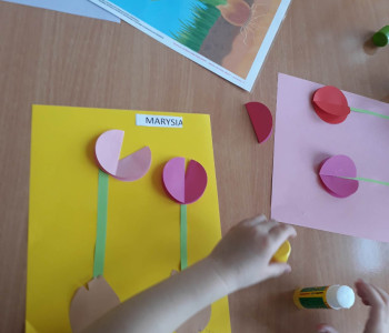 Dzieci przyklejają obiekt do pracy z kwiatkiem