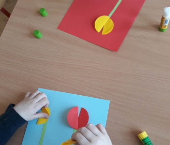 dwójka dzieci przykleja obiekty do pracy z kwiatkiem
