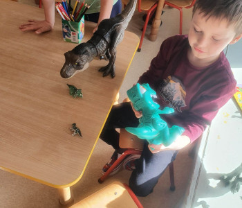 dzieci bawią się t-rexami