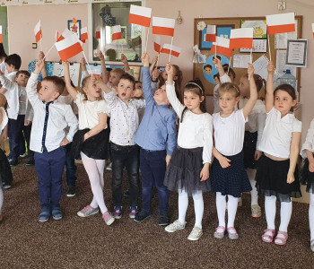 Zdjęcie grupowe dzieci machających flagami Polski