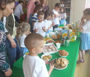 Dzieci zrodzicami korzystają z przygotowanego poczęstunku